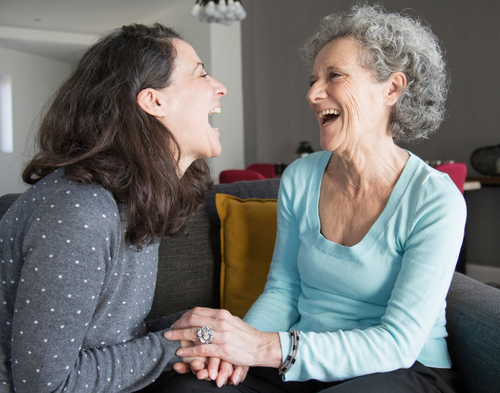 Two friends smile and hold hands